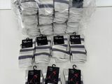 several pairs of white socks are wrapped in plastic bags on a table
