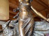 bronze statue of a woman holding a bird in a shop