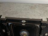 a black cabinet with a marble top in the corner of a room