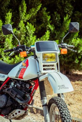 une moto rouge et blanche garée sur le bord de la route
