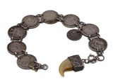 une image représentant un bracelet orné de pièces de monnaie et d'une dent