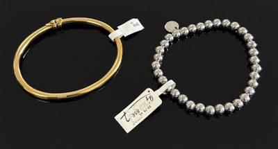 deux bracelets en argent et un bracelet rigide en or muni d'une étiquette