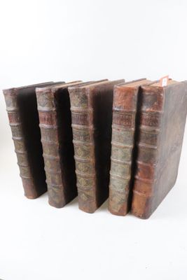 plusieurs vieux livres empilés sur une surface blanche