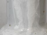 a white vase sitting on a table with a white cloth on it