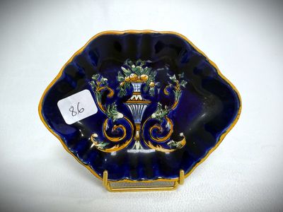 an image of a blue and gold plate with a vase on it
