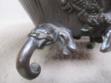 a statue of an elephant that is holding a cup