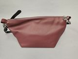 une petite pochette en cuir rose avec une anse noire