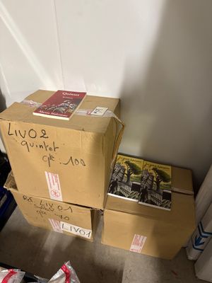 une pile de cartons posée par terre près d'un mur