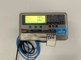 a close up of a digital meter on a table with a cord