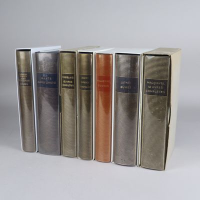 several books are lined up in a row on a white surface