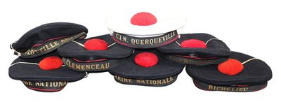several hats with red pom poms are stacked on top of each other