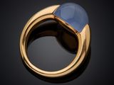 a close up of a gold ring with a blue stone