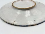 a white plate with a gold rim sitting on a white table