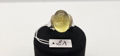 Gros plan sur une bague ornée d'une pierre jaune