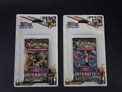 deux paquets de cartes à collectionner Pokémon posés sur une table noire