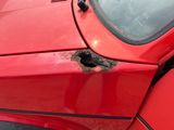 a red car with a hole in the side of it
