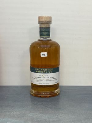 une bouteille de whisky posée sur une table à côté d'une bouteille de vin