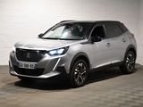 Le SUV argenté est garé dans une pièce blanche au sol carrelé.