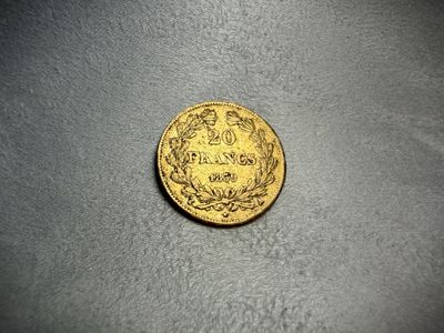 a close up of a gold coin on a gray surface