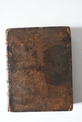 an old book sitting on top of a table next to a white wall