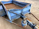 a blue trailer that is sitting in the dirt