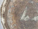 a close up of a brown plate with writing on it