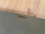 a laptop that is sitting on a table with a name plate