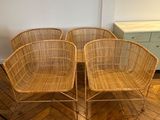 trois chaises en osier et une table dans une pièce au sol en parquet