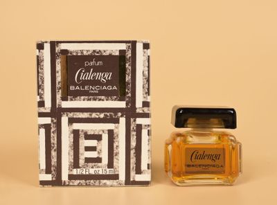 a close up of a bottle of perfume next to a box