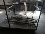 a metal cage that has a chair and a table inside of it