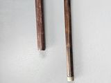 pair of wooden chopsticks on a white surface next to each other