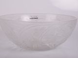 un saladier en verre transparent posé sur une surface blanche, muni d'une poignée argentée