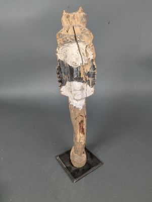 une statue en bois représentant un chat, posée sur un socle noir