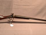 an old rifle with a wooden barrel and a green handle