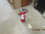 a fire extinguisor sitting on the floor in a warehouse