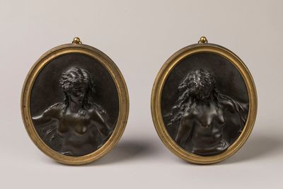 a pair of bronze plaques depicting a woman and a man