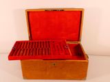 a small wooden box with a red lid on a white surface