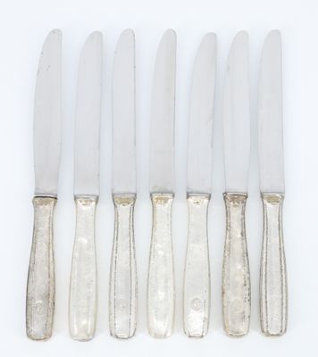 a set of five silverplated knives with a silver handle