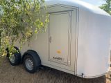 a white trailer that is parked in the grass