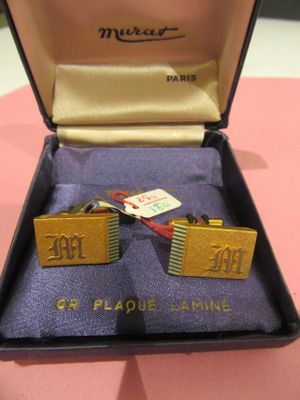 a pair of cufflinks in a box on a table