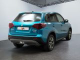 the rear end of a blue suv parked in a garage
