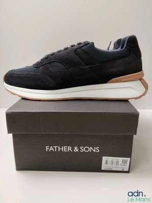 une paire de baskets noires posée sur une boîte