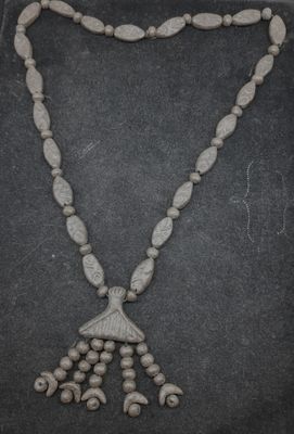 un gros plan d'un collier orné de perles sur un fond noir