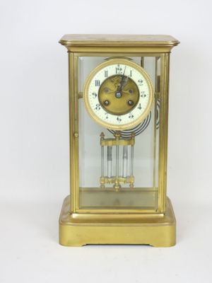 a gold clock that is sitting on a white surface