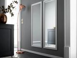 deux miroirs accrochés au mur, à côté d'une armoire noire