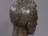 a bronze bust of a woman with short hair on a marble base