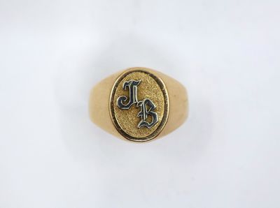 a gold signet ring with the letter l on it