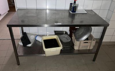 une table en métal sur laquelle sont posés une casserole et des poêles