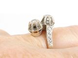 a silver ring that has two bells on top of it