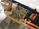 une boîte de verres vides et un parapluie par terre